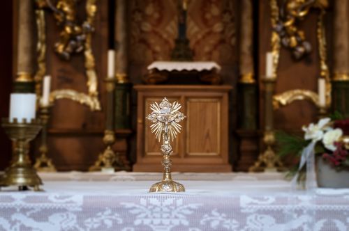 Free A detailed view of a gold cross on the altar inside a traditional church, highlighting religious symbolism. Stock Photo