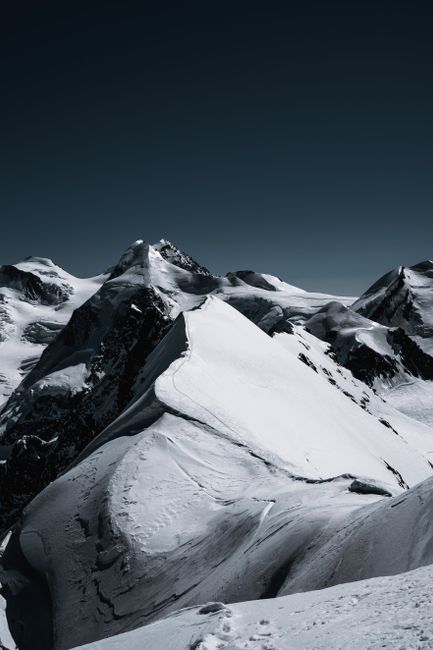 Breathtaking view of the snow-capped peaks in the Swiss Alps under a clear sky.