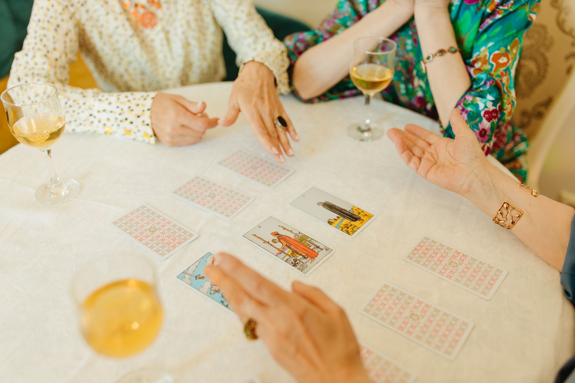 A group of senior women enjoy a tarot card session indoors, emphasizing friendship and leisure.