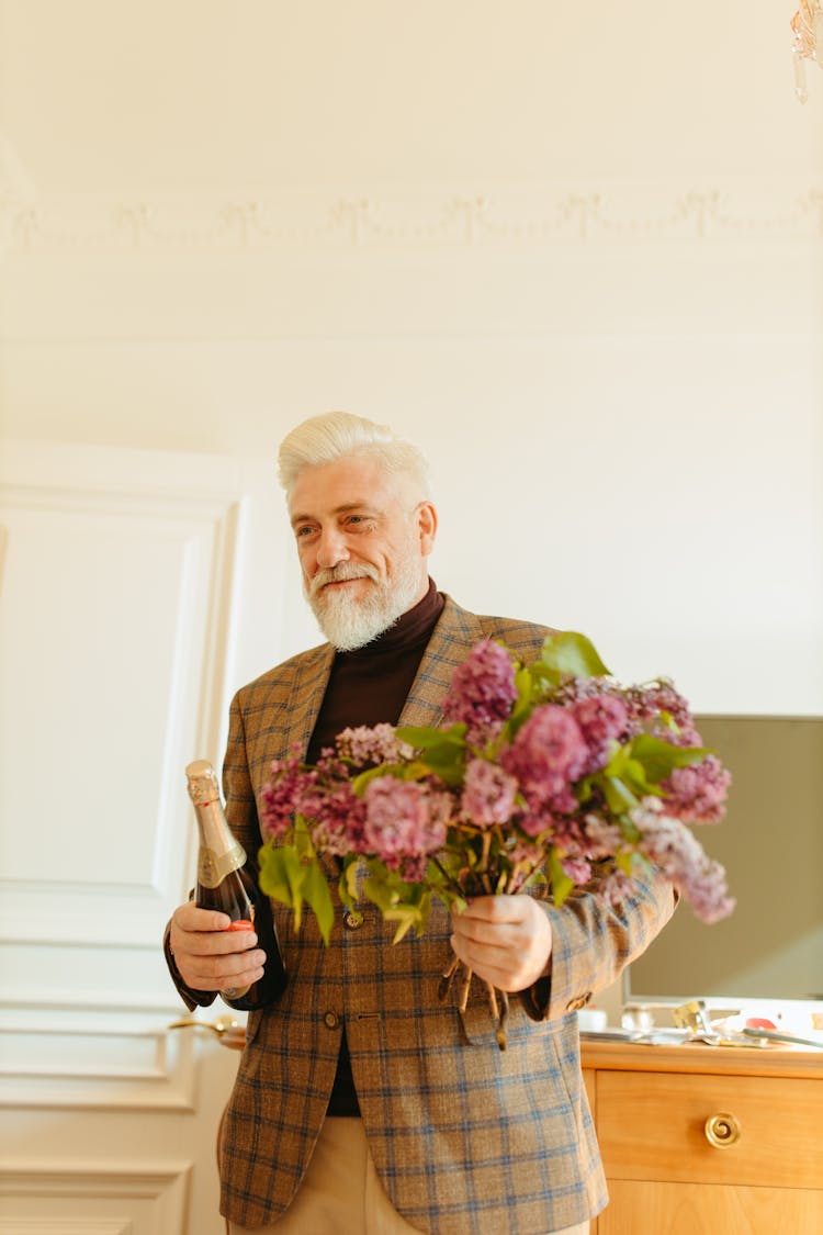 Elderly Man In Brown Plaid Coat Holding Bouquet Of Flowers And Wine Bottle