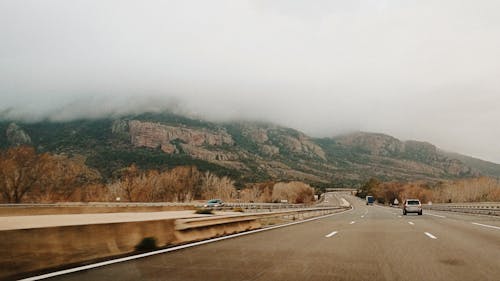 Carros Na Estrada De 4 Pistas Perto Do Vale E Da Montanha Durante O Dia