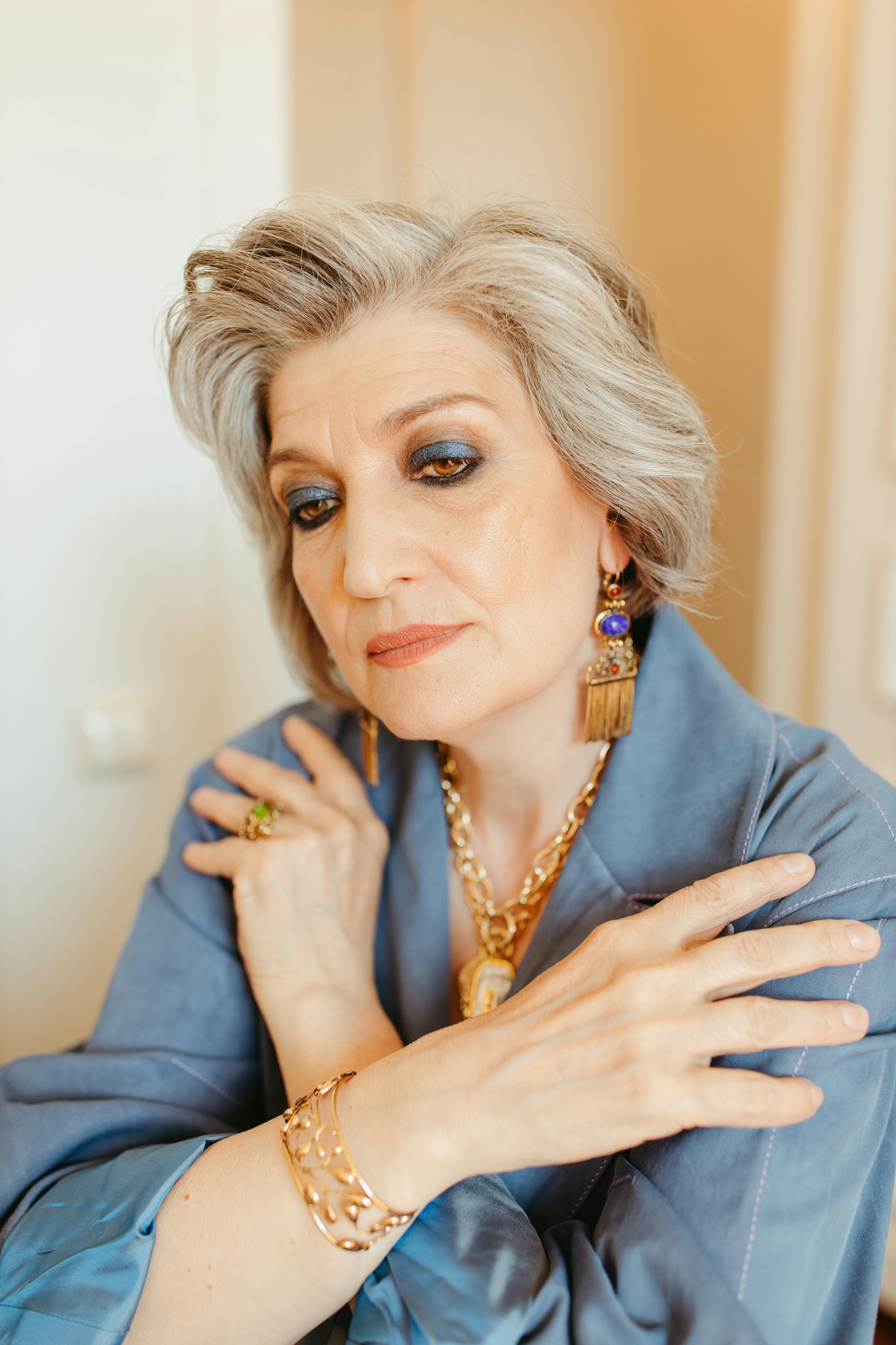 woman in blue long sleeve wearing gold accessories