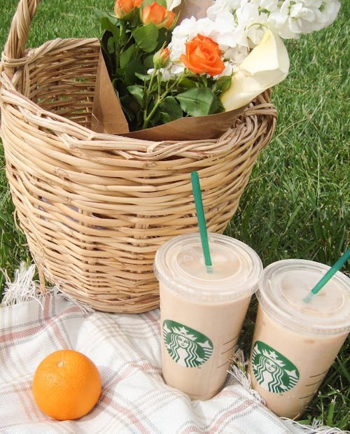 Starbucks Coffee and Basket on Grass Field 