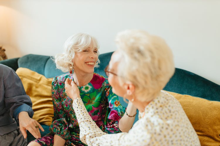 Elderly Woman Showing Her Earring To Her Friend