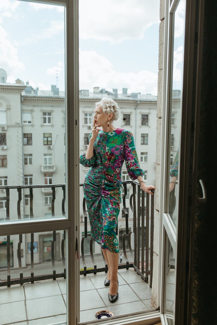 Elderly Woman Smoking Cigarette At The Balcony