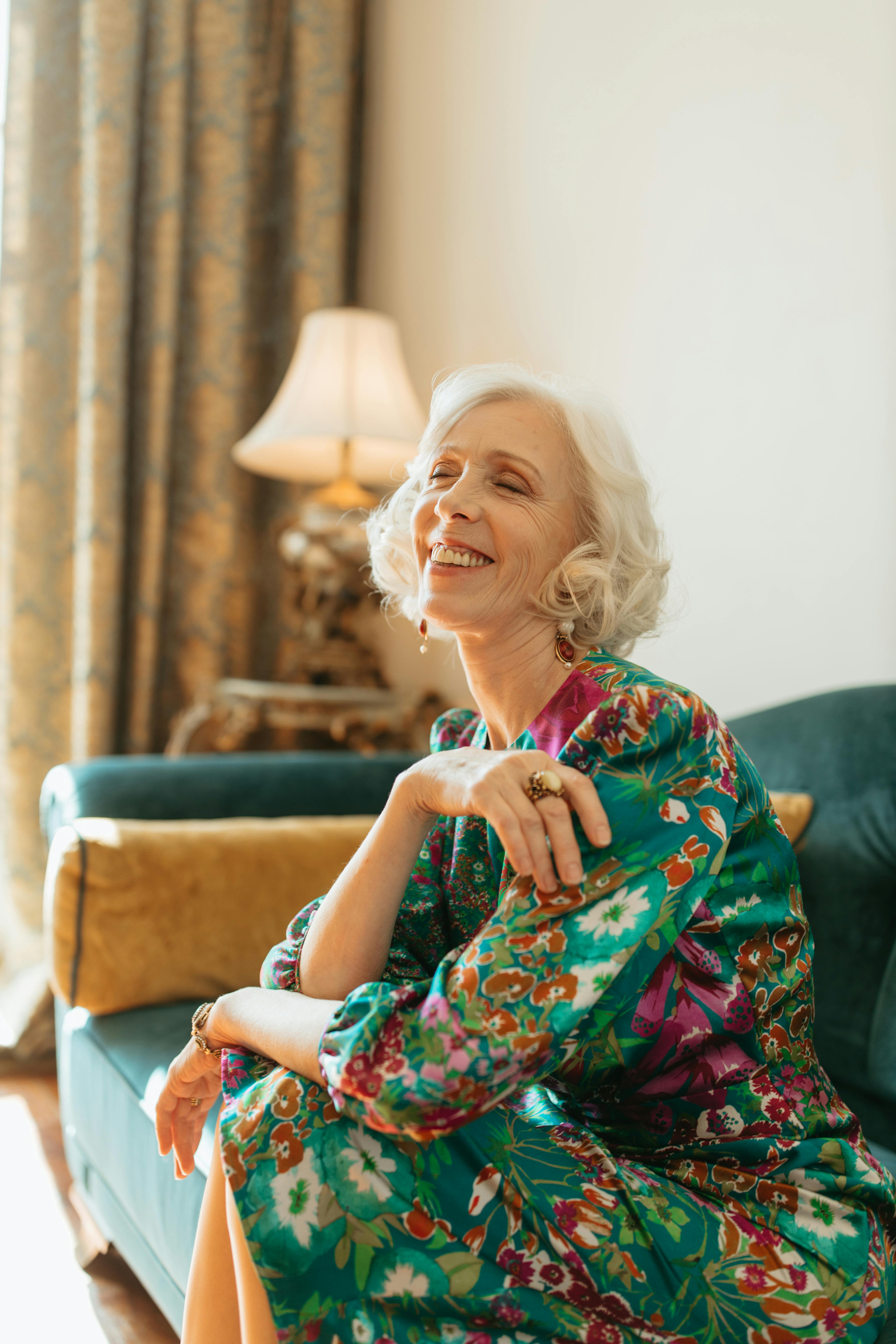 happy woman sitting on a green velvet couch