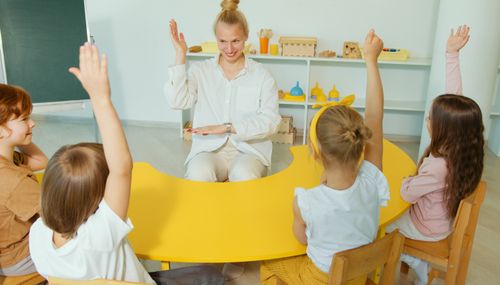 Free A lively preschool class with children participating in a learning activity guided by a cheerful teacher. Stock Photo