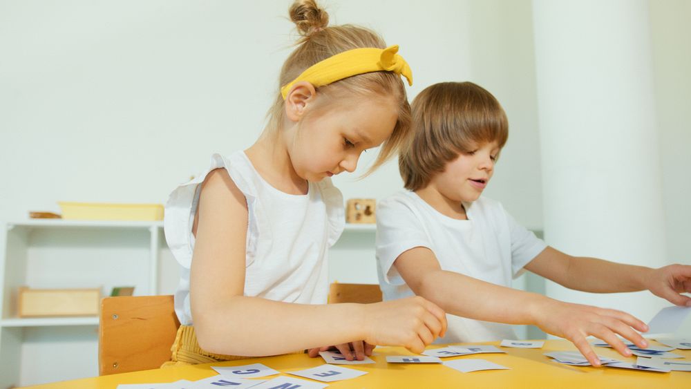Two young children working on a letter activity