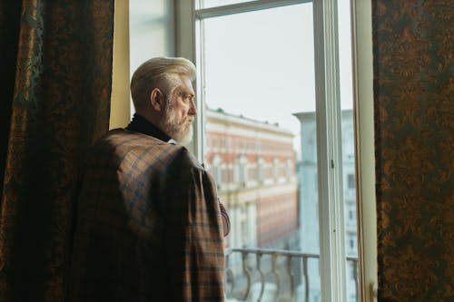 An Elderly Man Looking at the Window