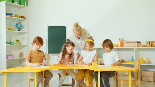 Blonde Woman Checking the Kids Writing 