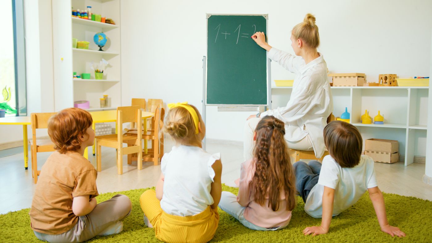 Teacher guiding children in a bright early learning classroom