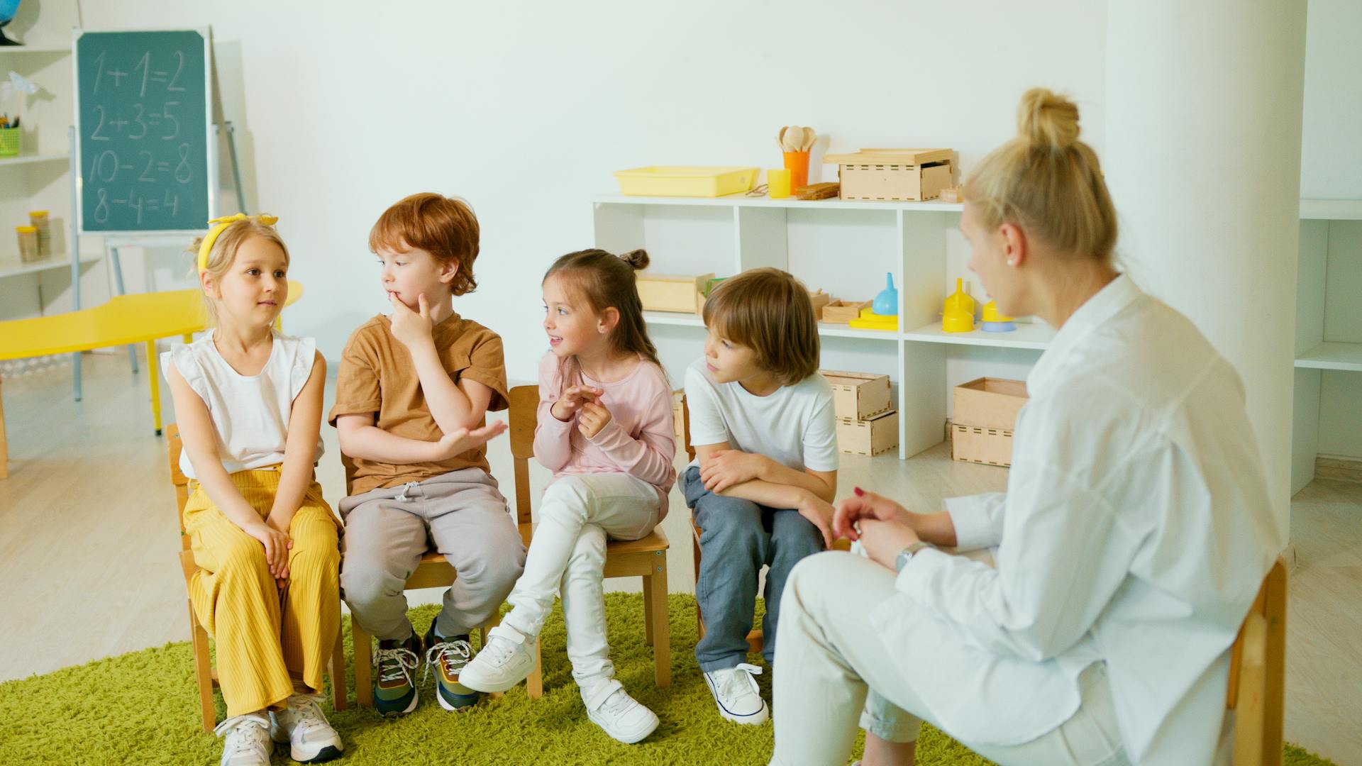 A group of children interacting in a classroom with their teacher, fostering learning and social skills.
