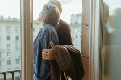 Free Elderly Couple Standing Together at the Balcony Stock Photo