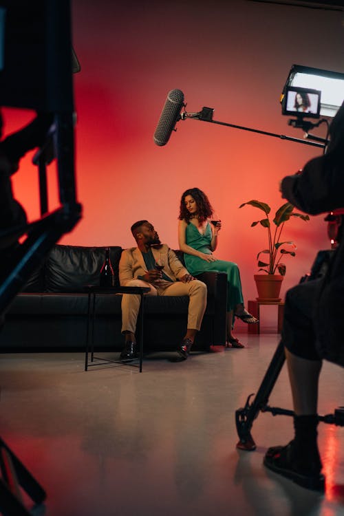 A Man in Brown Suit Sitting Beside a Woman in Green Dress