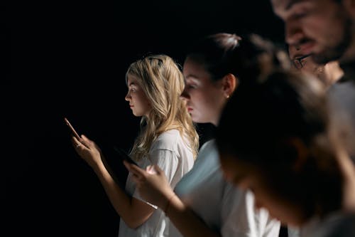 Photo of Woman in White Shirt Holding Smartphone