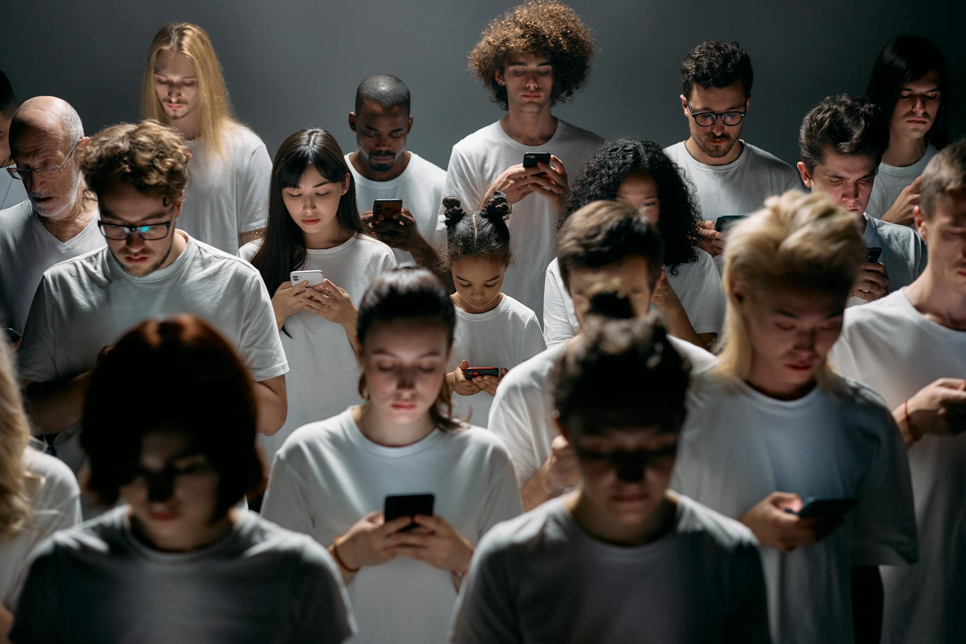 A diverse crowd of people using smartphones, highlighting modern social connections and isolation.