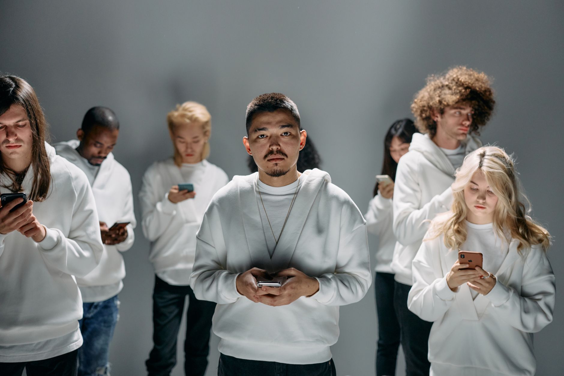 A diverse group of adults engaging with smartphones, depicting social connection amidst isolation.