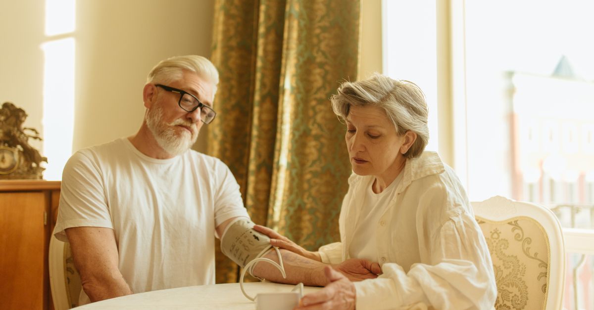 An elderly couple at home measuring blood pressure with a digital monitor, depicting care and health awareness, illustrating COPD Management at Home for the Elderly โ 1-800-MEDIGAP, America's Trusted Toll-Free Number.