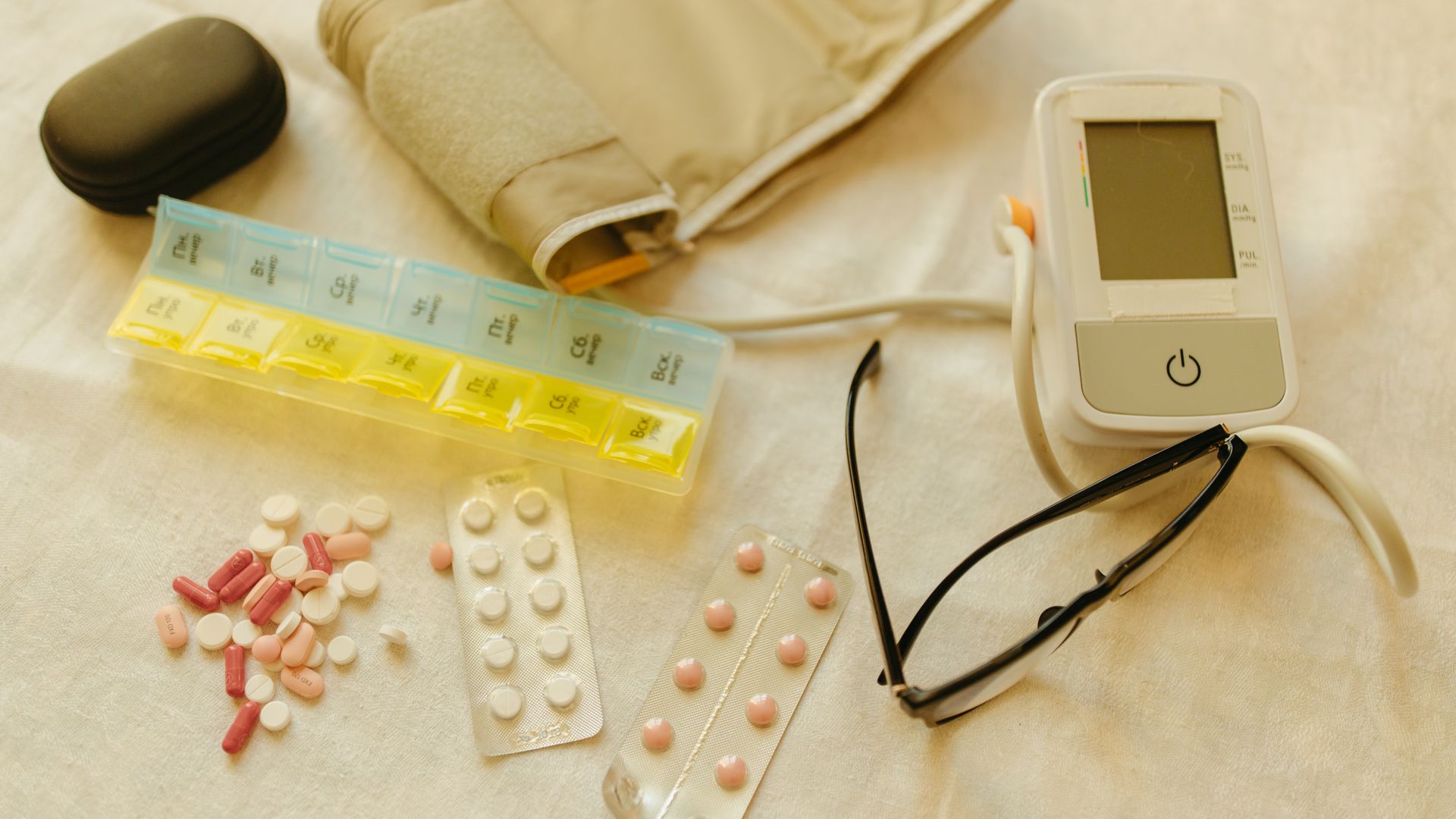 Modafinil and High Blood Pressure: Exploring the Link Flat lay image of healthcare essentials including a blood pressure monitor, pills, and eyeglasses on a white surface — modafinil and high blood pressure