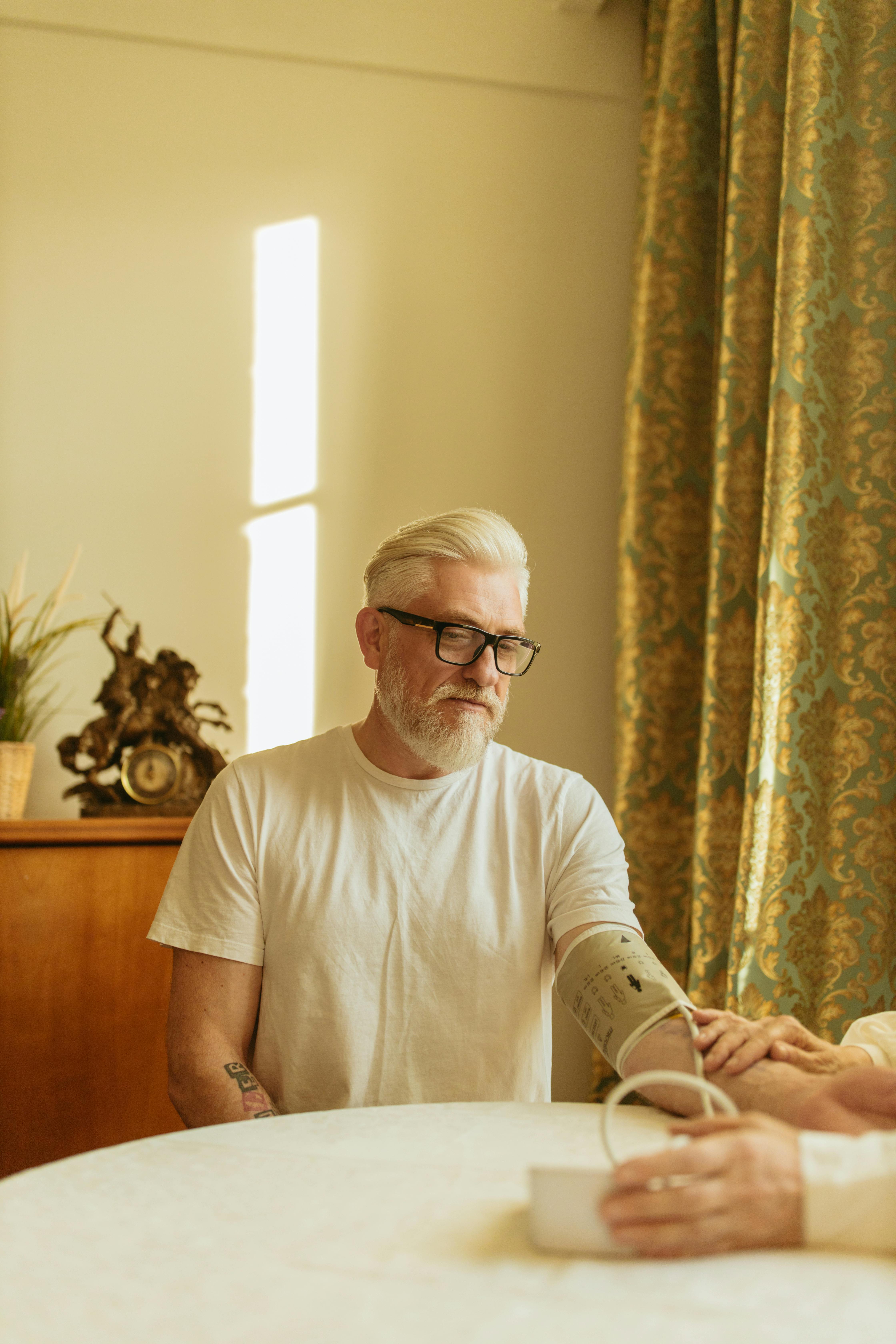 person checking elderly man s blood pressure