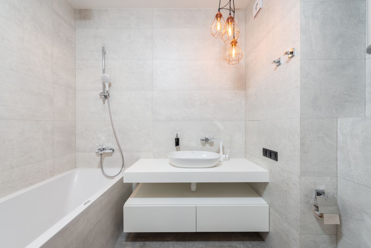Bright, modern minimalist bathroom with marble tiles and elegant vanity. Stock Photo.