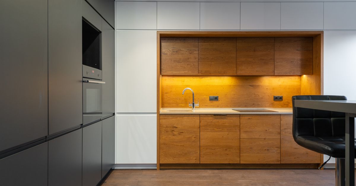 Cozinha contemporânea ampla com detalhes em madeira e iluminação abundante