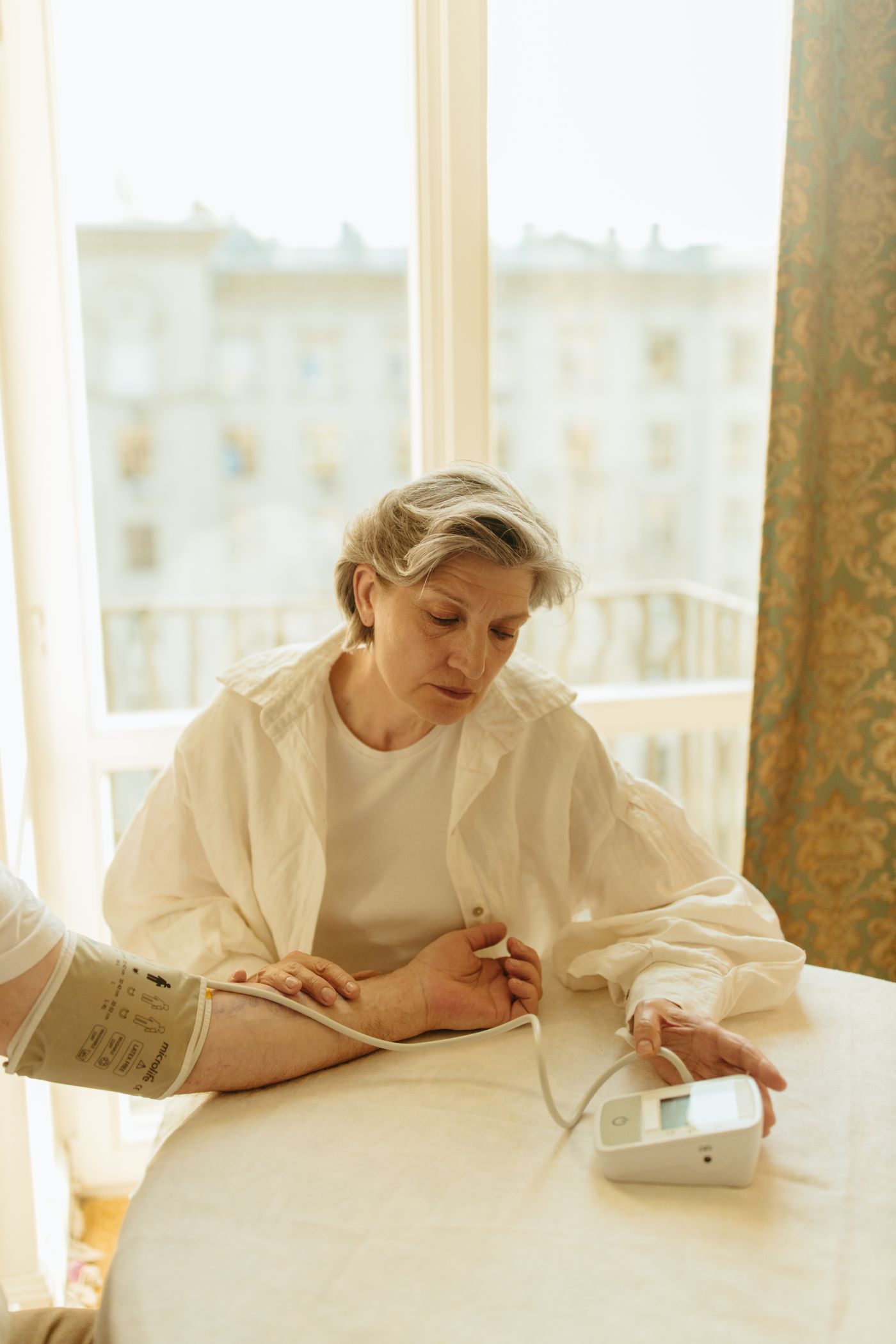 A woman checking her blood pressure at home