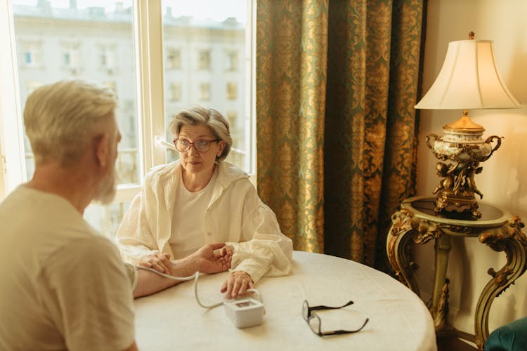 Elderly Woman Checking Blood Pressure Of Mature Man