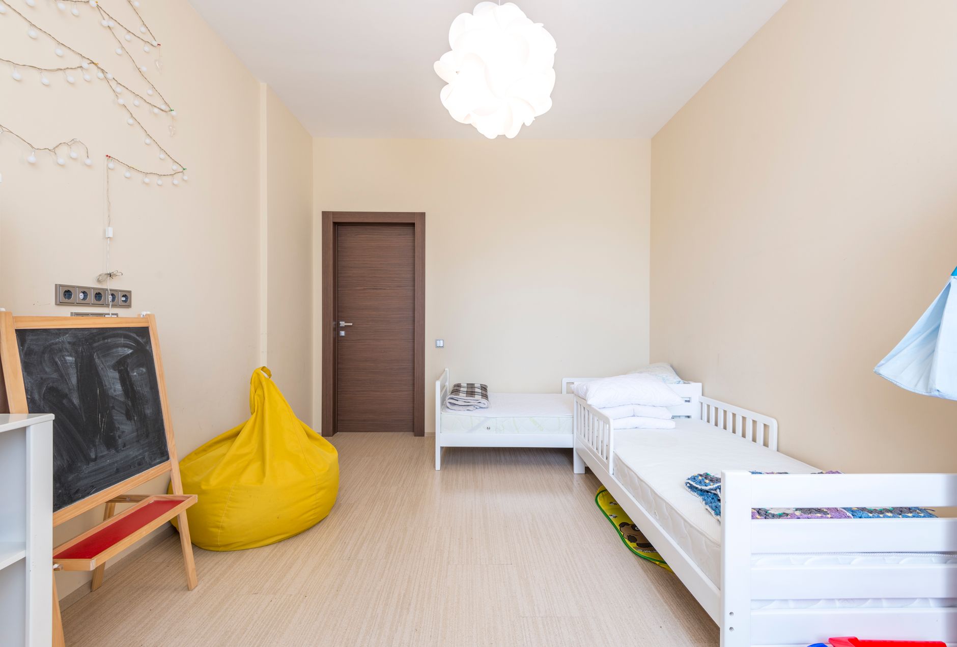 Bright and cozy children's bedroom featuring twin beds and minimalist decor.