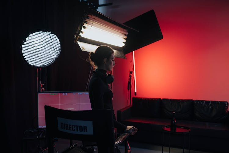 Woman In All Black Outfit Standing In Front Of Director's Chair 