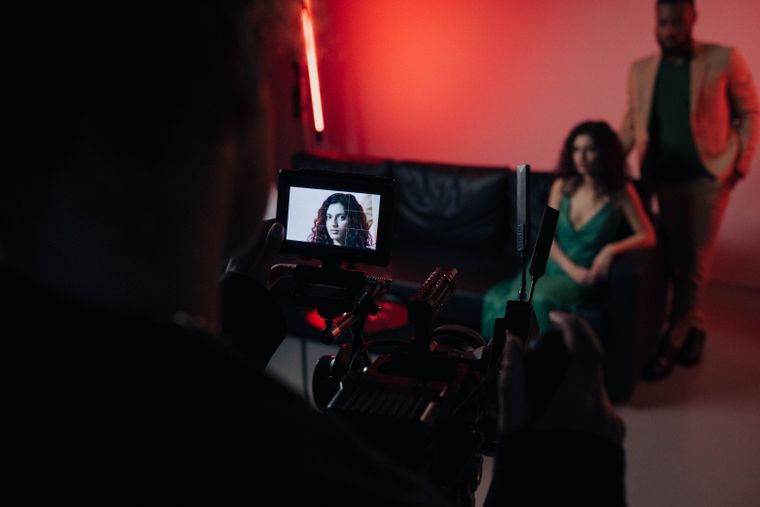Two actors on a red-lit film set, photo by Ron Lach on Pexels
