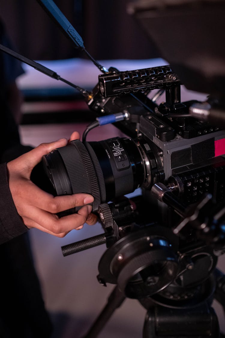 A Person Holding The Lens Of A Video Camera