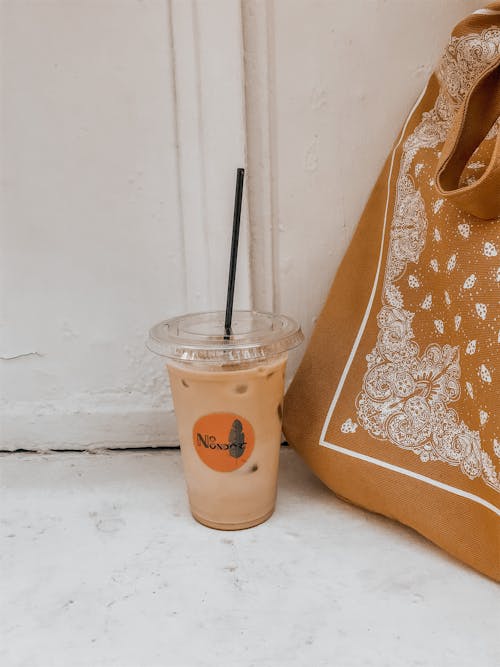 A Disposable Cup with Straw on a White Surface