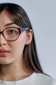 Close-up of a woman with glasses, showing facial recognition laser scanning.