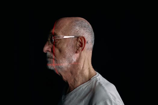 Side profile of a senior man with facial recognition scan lines on a plain black background.