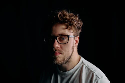 Low Light Photo of Man in White Crew Neck Shirt