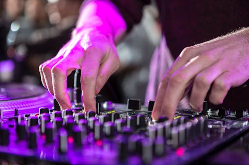 A Close-up Shot of a Person Using an Audio Mixer