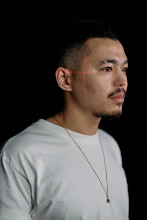 Free Studio portrait of a man with laser scanning lines, exploring facial recognition technology concepts. Stock Photo