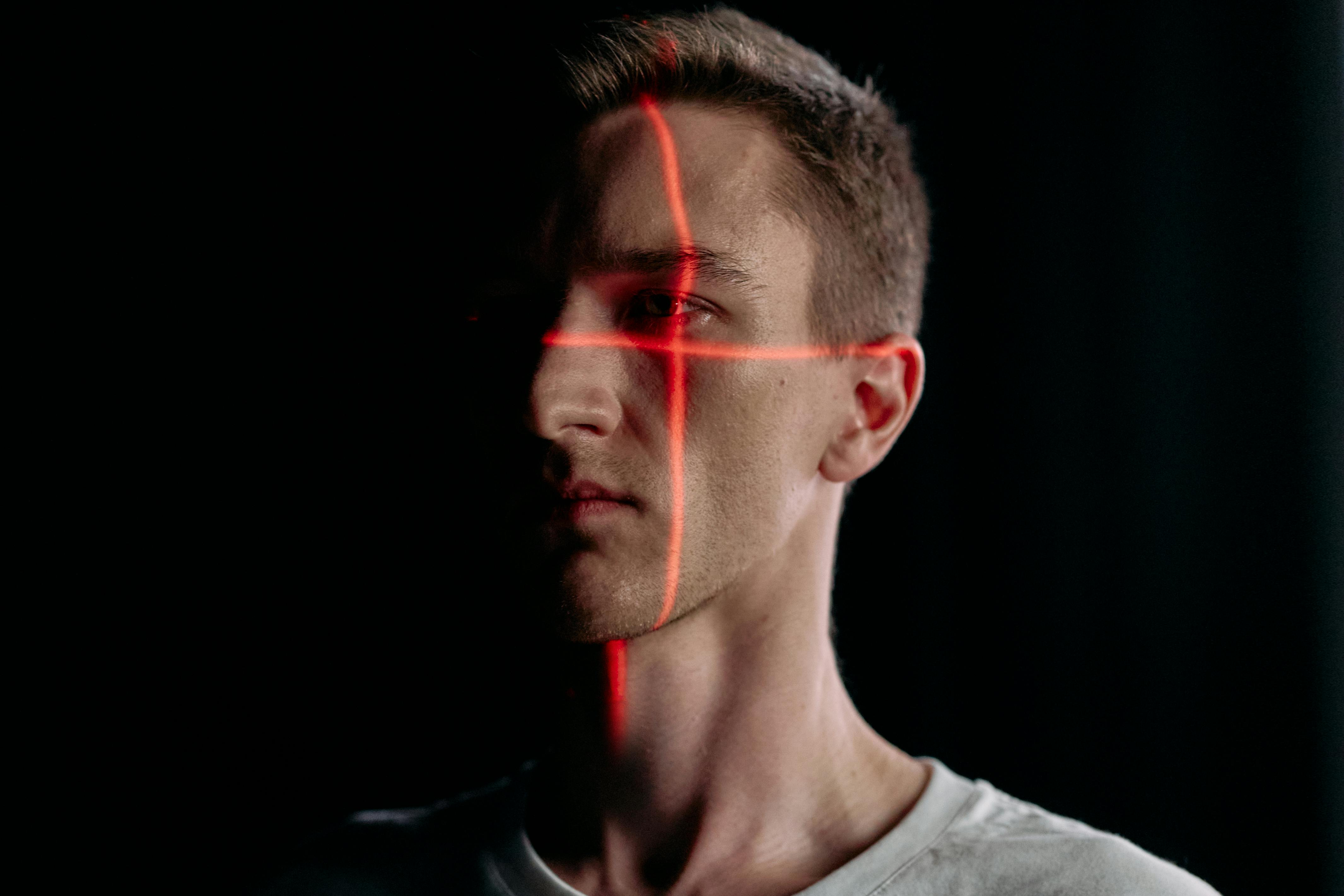 close up photo of man with laser lines on his face