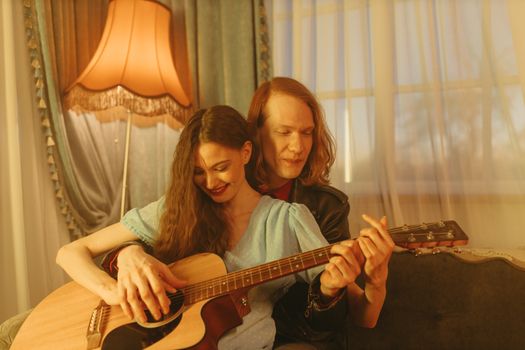 Woman in White Long Sleeve Shirt Playing Brown Acoustic Guitar