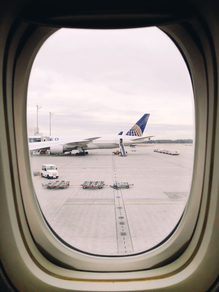 View Of Airplanes At The Airport Seen From An Airplane Window