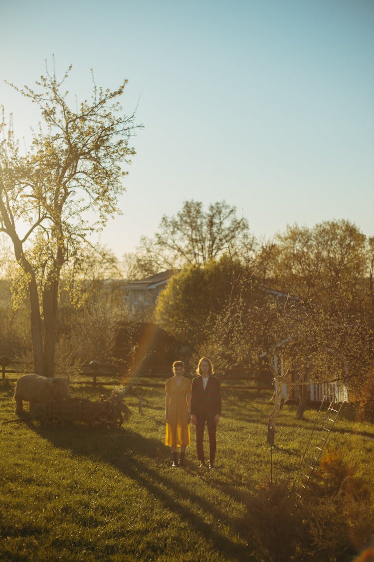 Couple Standing On Green Grass Field