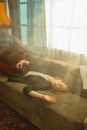 Woman in Gray Long Sleeve Shirt Sitting on Brown Couch