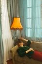 Man in Green Shirt Lying on Brown Sofa