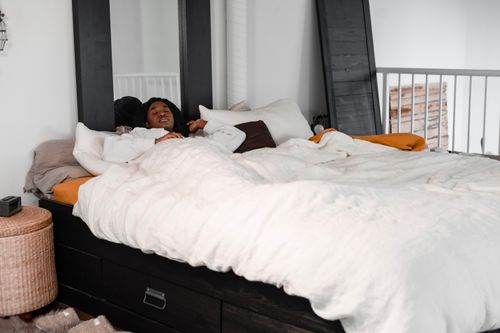 Free Serene image of a person sleeping in a white bed with cozy decor. Ideal for lifestyle themes. Stock Photo