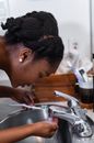Close-up Photo of Woman washing her Mouth on a Sink