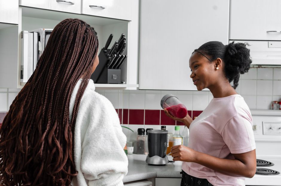 Best Blenders and Food Processors: Complete Kitchen Tool Guide Two women preparing a refreshing drink together in a modern kitchen setting.