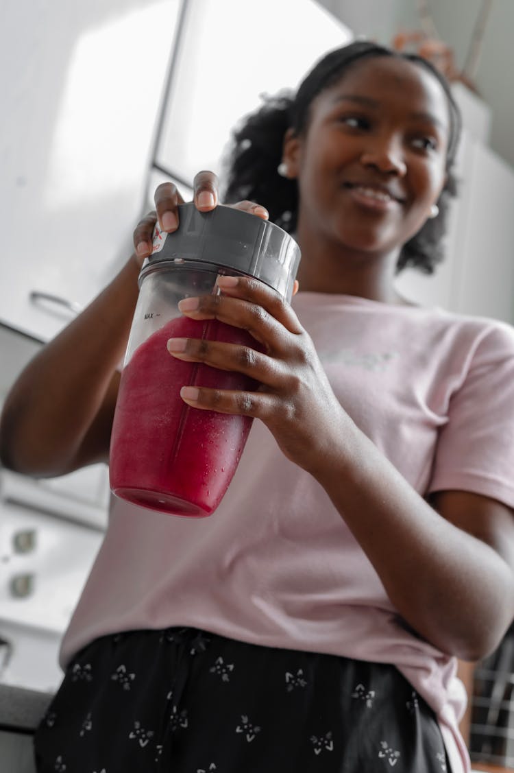 A Woman Holding A Blender 