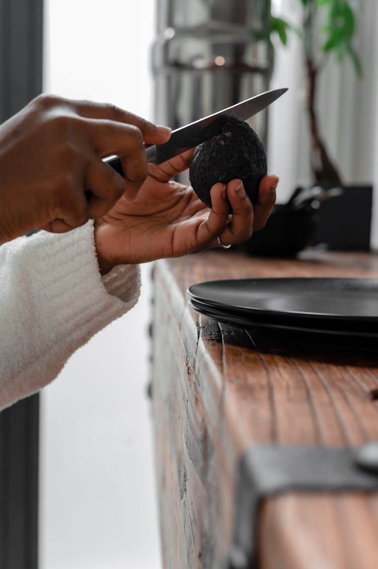 A Person Cutting An Avocado