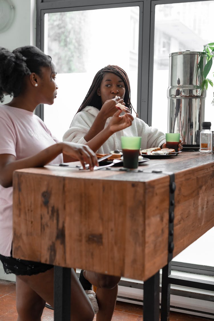 Women Eating Breakfast At Home While Having A Conversation